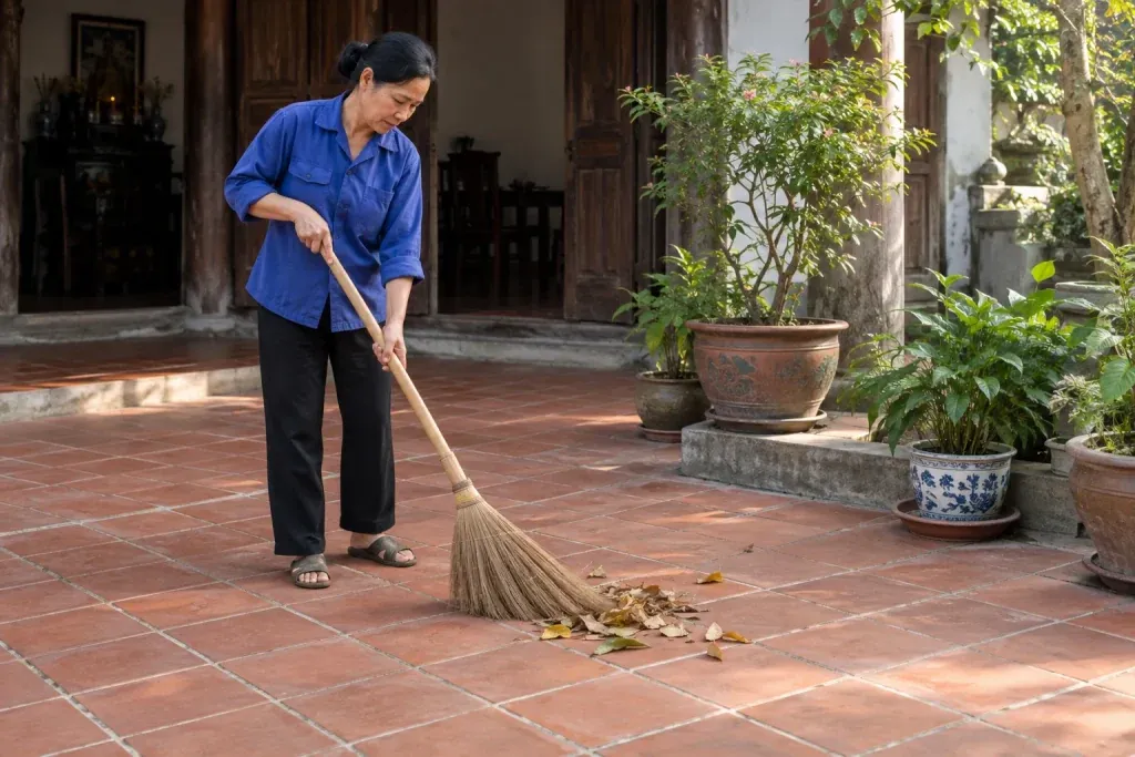 Ảnh minh họa thu lá khô trên nền gạch đỏ đất nung tại hiên có chậu cây